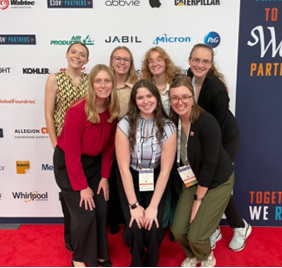 Sseven women smiling for a group picture