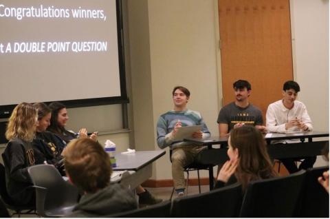 People sitting at tables in front of an audience