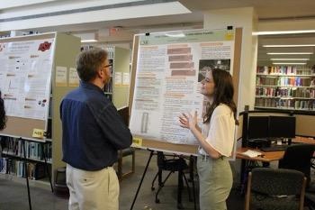 Two people standing in front of a research poster
