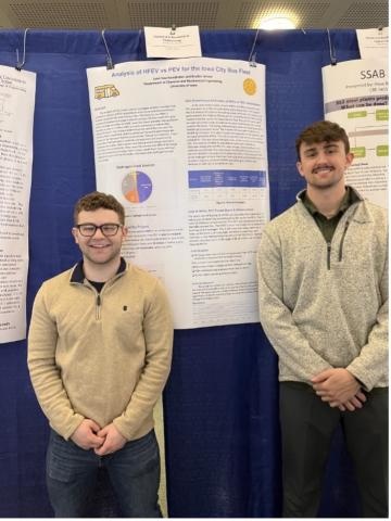 Two students pose with their research poster